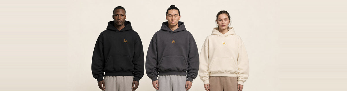 Three models in the oversized hoodie, in black, charcoal and cream